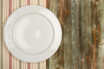 Empty white plate on wooden table