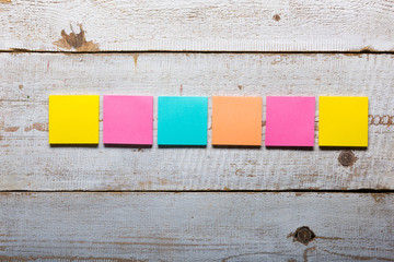 Retro white wooden table with empty colorful sticky notes