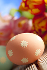 Orange Easter egg and colorful spring flowers