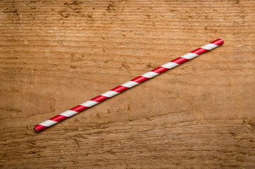Red drinking straw on wood background