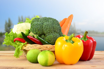 Vegetables in basket on wooden and nature background.