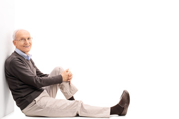 Senior gentleman leaning against a wall