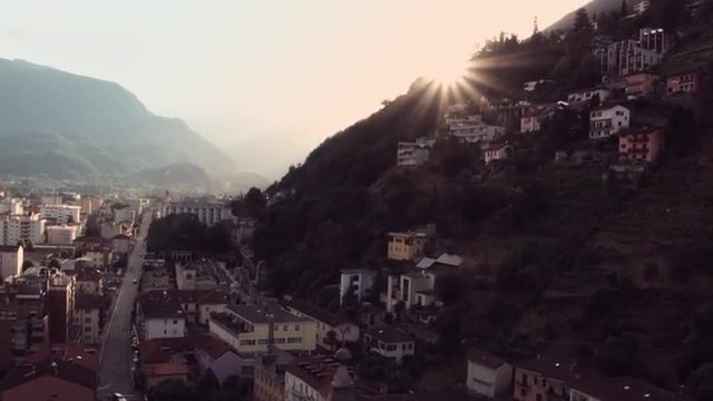 Flight over Mediterranean village with church and sunset
