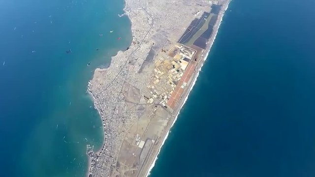 Group of skydivers are hovering in accelerated free fall above coastal city