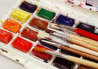 Bright watercolor paints and used brushes for painting. close-up. 