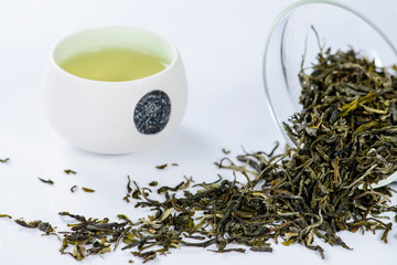 Fototapeta premium green tea Mengding, brewed in a cup and scattered tea, shallow D