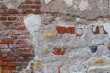 old brick wall with damaged plaster