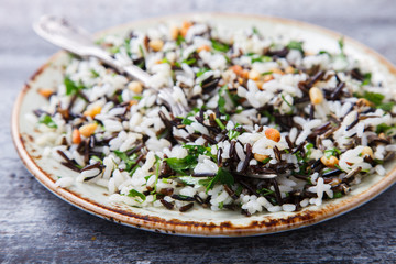 Salad of white and wild rice with pine nuts and herbs.selective focus.