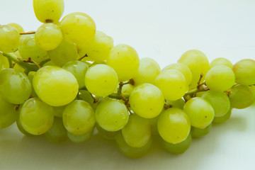 bunch of ripe and juicy green grapes close-up on a white background