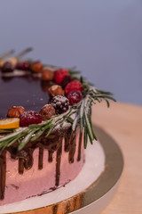 Wild berry Birthday cake with chocolate glaze, rosemary and berries on top