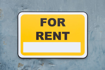 Yellow for rent sign on metal wall