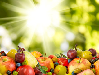 various ripe fruits and berries close up on a green background
