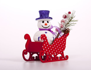Christmas snowman in a sleigh on a white background