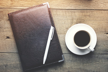 pen on notebook and coffee on table