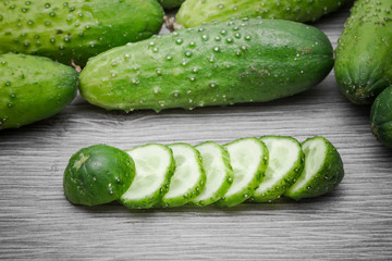 Cucumber on gray wooden surface texture.