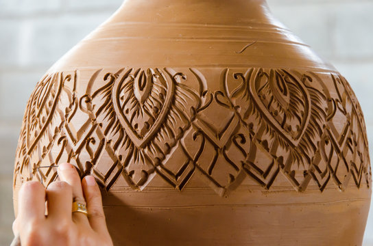 Hands of making clay pot on the pottery wheel ,select focus, close-up.
