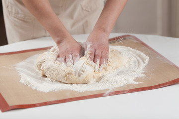 Obraz na płótnie Canvas Making dough by hands at bakery