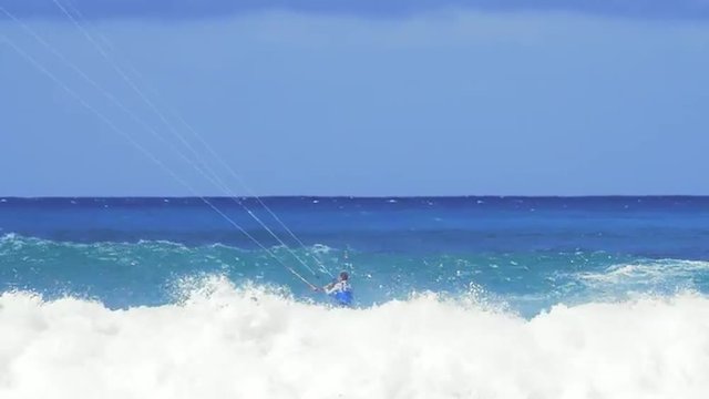 Surfing with kite in ocean. Male athlete surfer in action