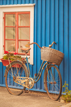 Old rusty lady bicycle in front of a Swedish house