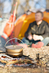 pot on a fire burning in a tent