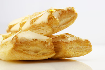 Confectionery theme. Three puff a cookies, topped with honey on a bright surface.