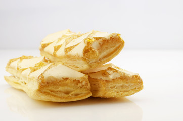 Confectionery theme. Three puff a cookies, topped with honey on a bright surface.