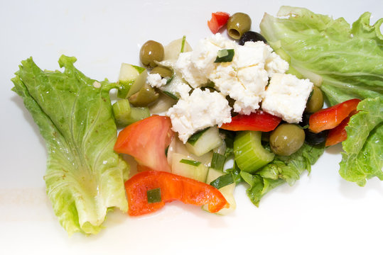 Greek vegetable salad with feta cheese on a white plate