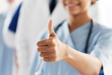close up of doctor or nurse showing thumbs 