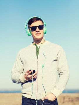 happy young man in headphones with smartphone