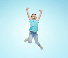 Fototapeta na wymiar happy little girl jumping in air over blue