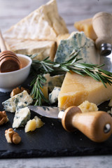 Delicious cheeses on a board with honey, nuts