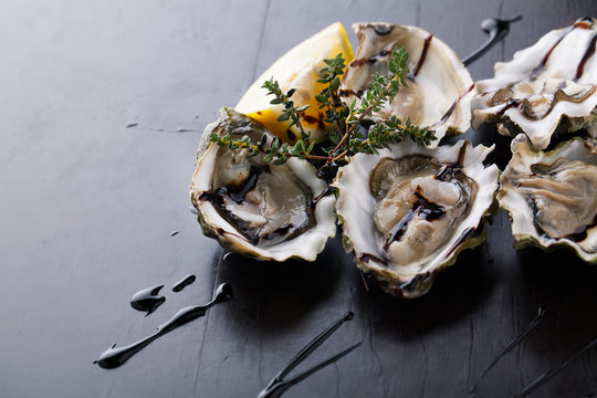 Fresh Oysters in shell with sauce and lemon