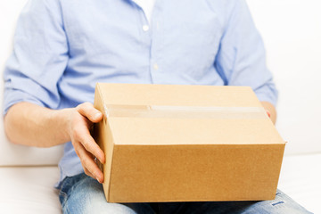 close up of man with cardboard box parcel at home