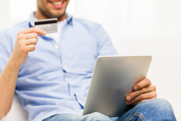 close up of man with tablet pc and credit card