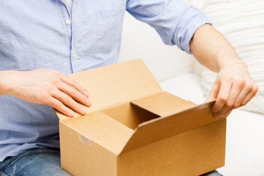 close up of man with cardboard box parcel at home