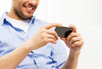 close up of man with smartphone at home
