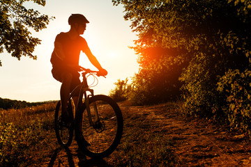 Fototapeta na wymiar Man Cyclist with bike on sunset