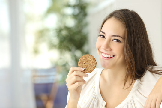 Happy girl showing a dietetic cookie