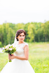 Fototapeta na wymiar Young bride holding big wedding bouquet