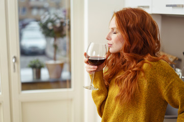 frau trinkt ein glas rotwein zu hause
