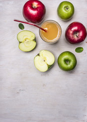 fresh apple juice from apples of different varieties border ,place for text  on wooden rustic background top view close up