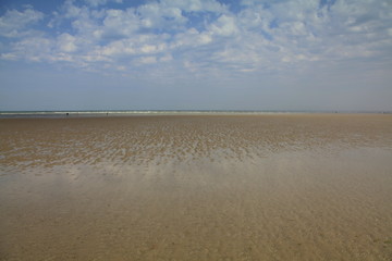 L'immensité paisible de la plage à marée basse. - obrazy, fototapety, plakaty