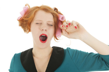 Woman with curlers in hair yawning