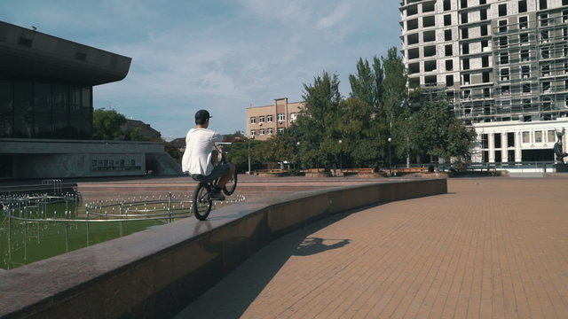 	BMX rider doing tricks in the city, slow motion, steadycam