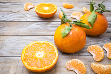 several mature citrus on an old wooden table - mandarins and leaves
