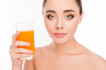Close up photo of smiling woman holding a glass of orange juice