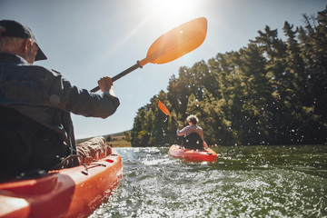 Senior couple kayaking in a lake - obrazy, fototapety, plakaty