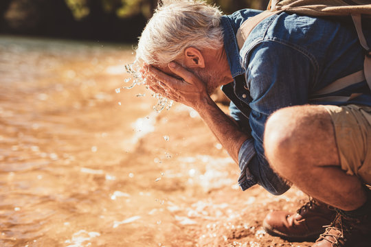 Mature man getting fresh during a hike