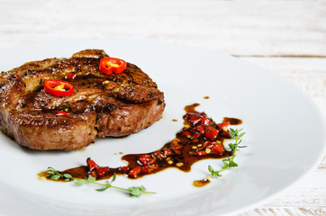 steak on white plate with chili