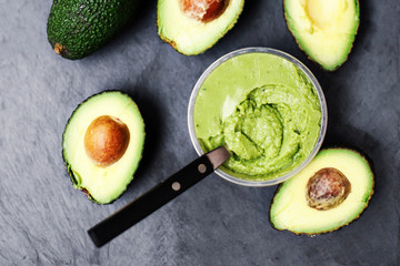 Guacamole. Avocado on a black background, top view image.